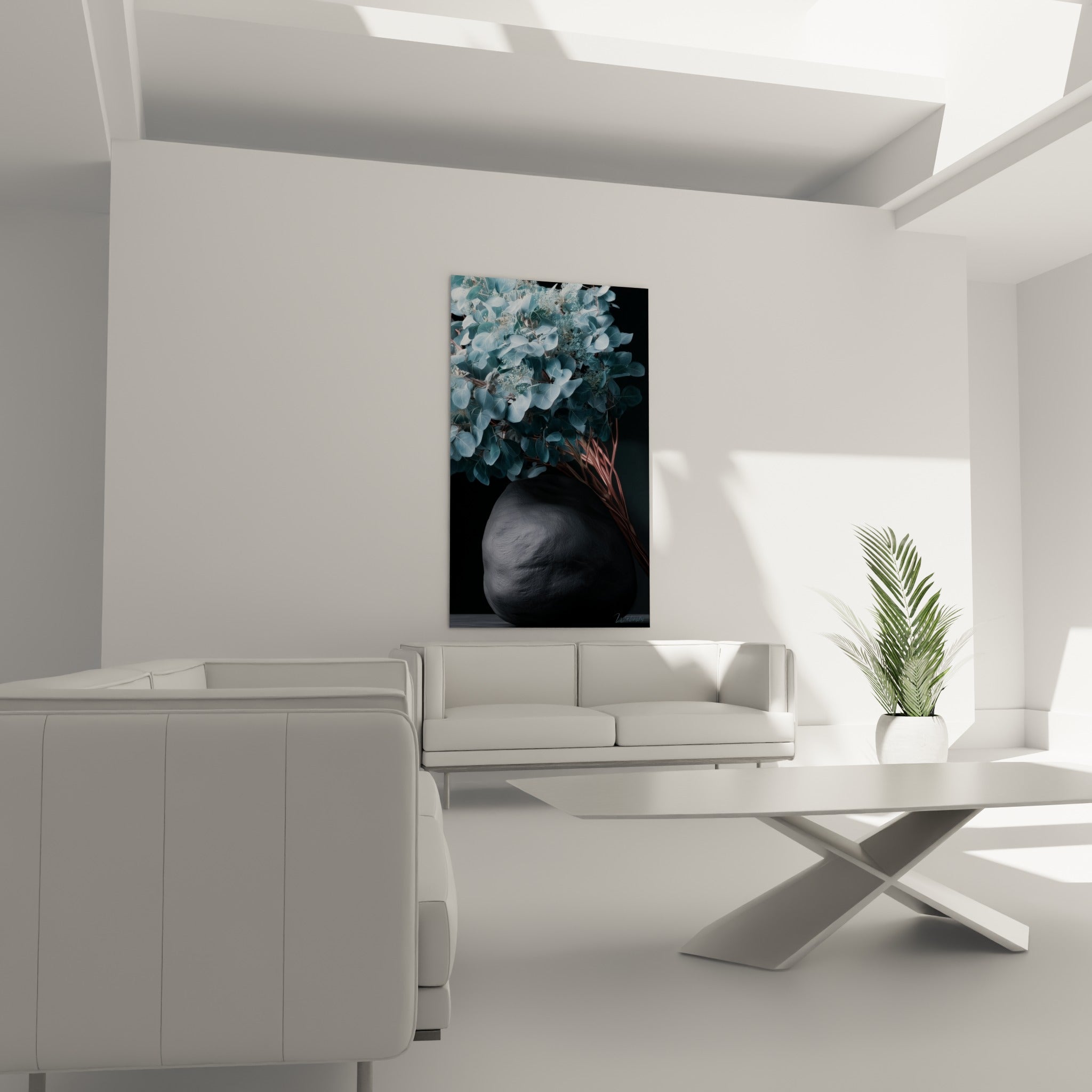Bouquet d'Eucalyptus bleuté et vase anthracite granuleux au-dessus d'un canapé dans un salon lumineux