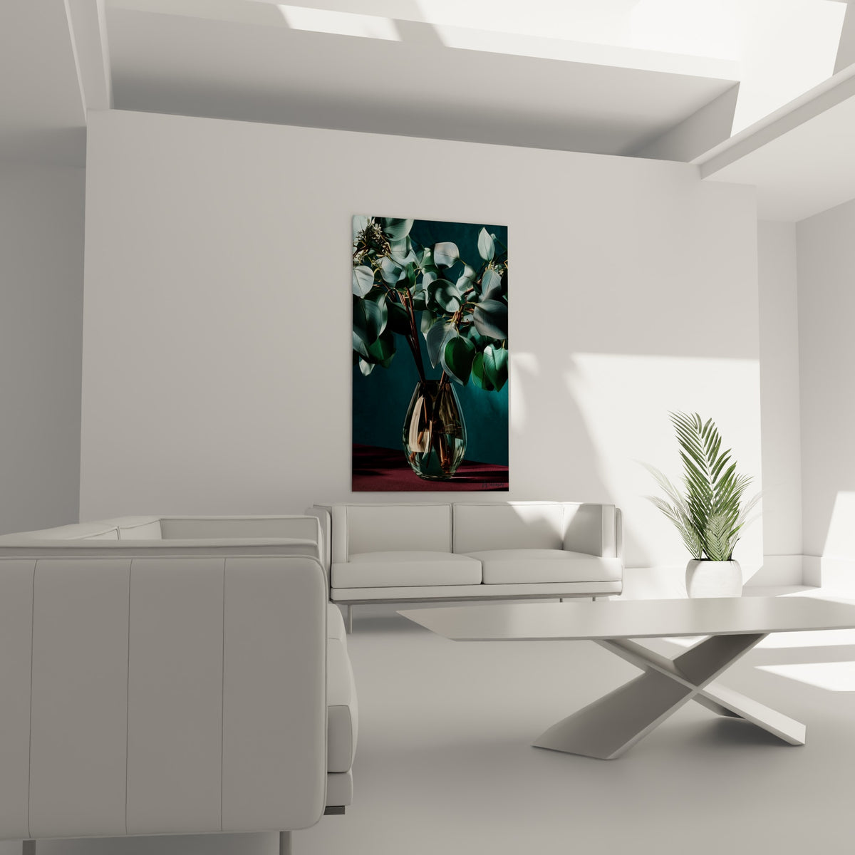 Vase de verre et eucalyptus vert sauge disposé au-dessus d'un canapé dans un salon lumineux