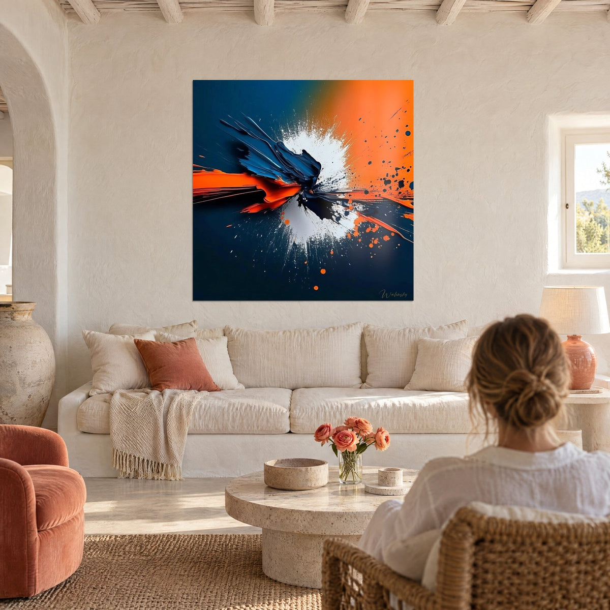 Tableau explosion de peinture bleu nuit et orange vif, éclaboussure blanche, au-dessus d'un canapé dans un salon lumineux