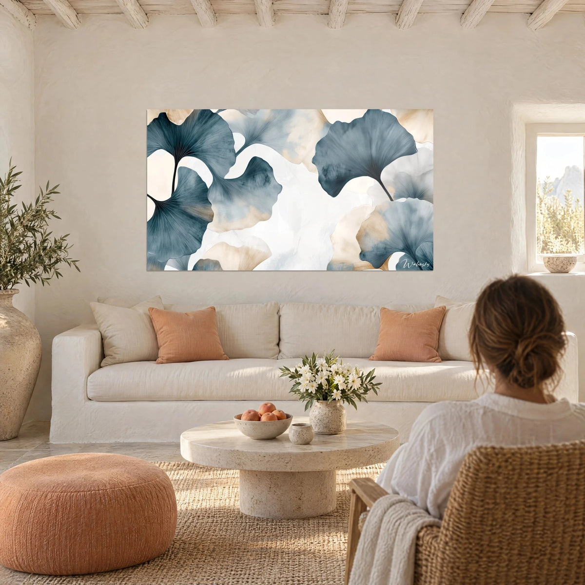 Wall art of teal-blue and sand-beige ginkgo leaves in watercolour, fine veins, above a sofa in a bright living room