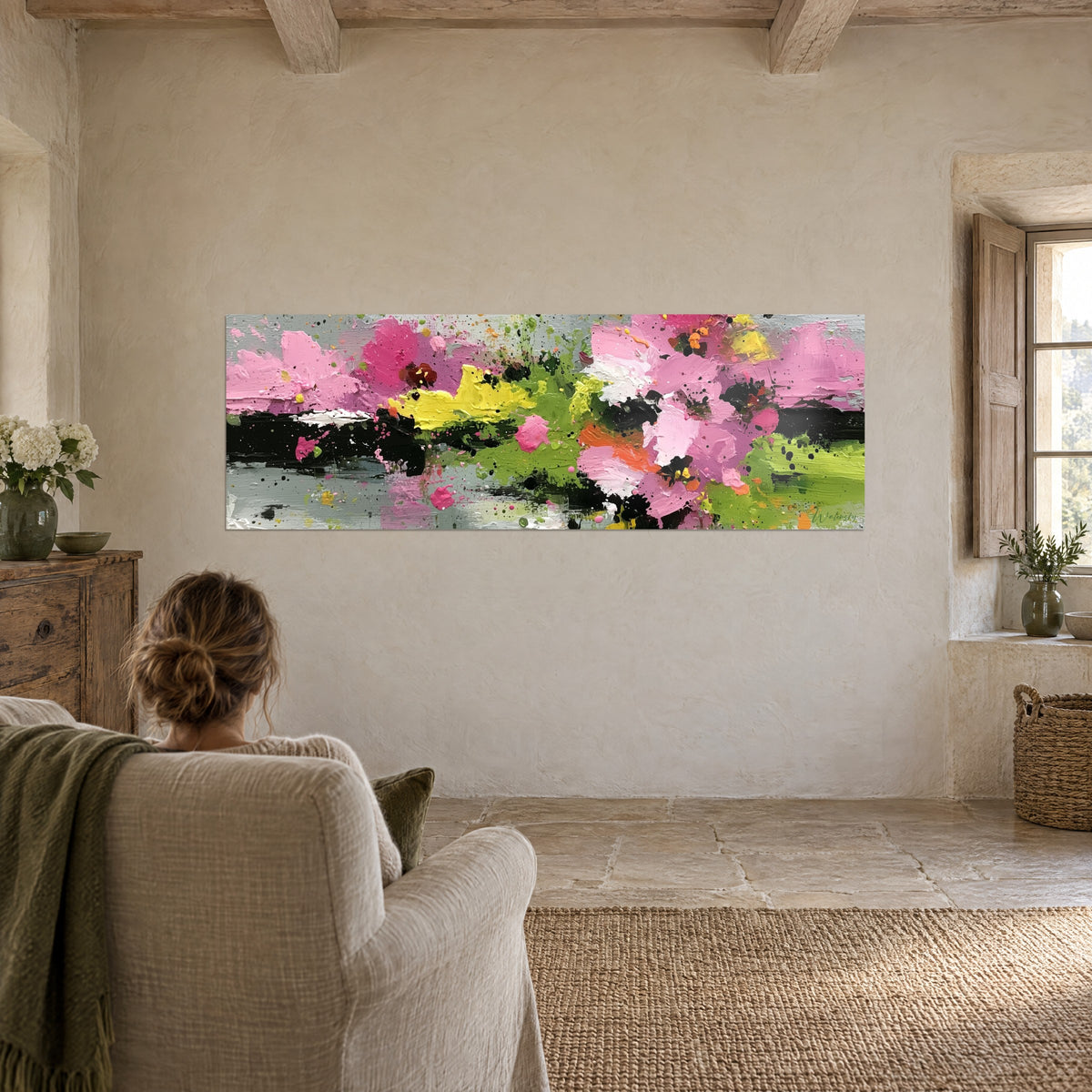 Cuadro pradera abstracta de flores rosas con toques naranjas, banda verde y negra, mujer de espaldas en un sillón de piedra de una casa