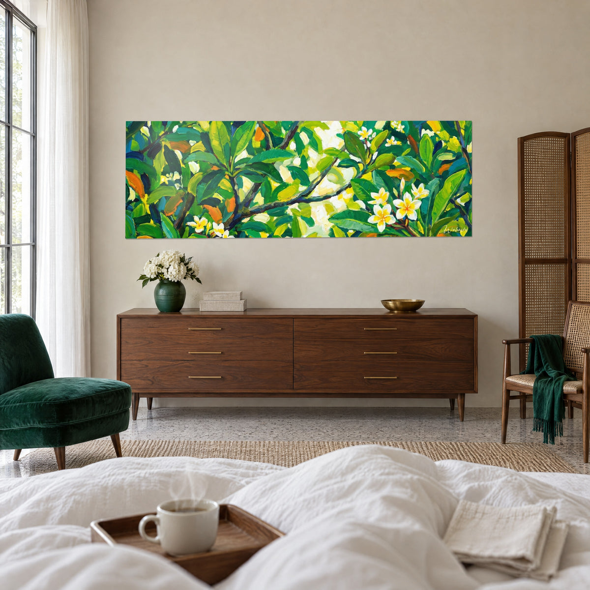 Tableau branches de frangipanier et pétales blancs sur fond de verts profonds et d'orangé, face à une personne de dos, au-dessus d'un lit dans une chambre claire