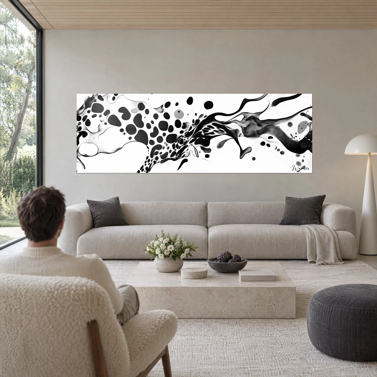 Quadro di flusso d'inchiostro nero maculato che squarcia uno sfondo bianco, schizzi grigi, uomo di spalle, sopra un divano in un soggiorno luminoso