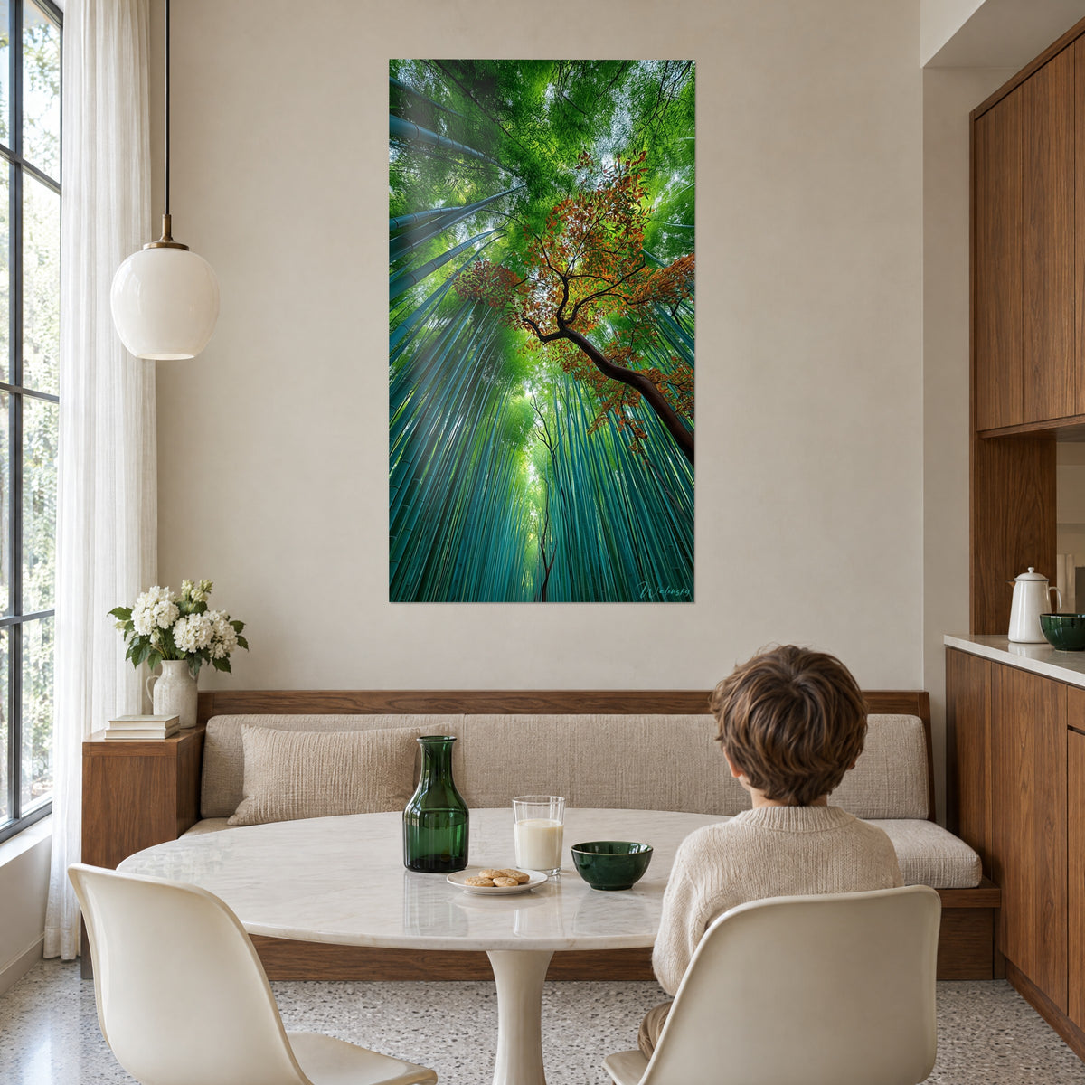 Quadro volta di fogliame verde vivo e tronco bruno d'acero in diagonale, bambino di spalle al tavolo, sopra una panca in legno