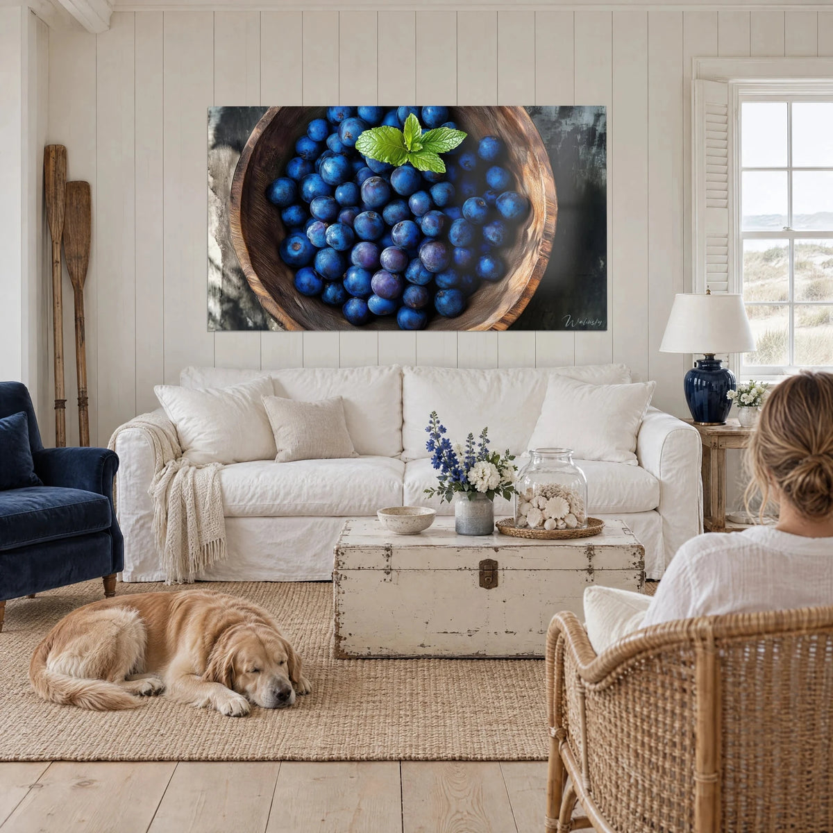 Schilderij blauwe bosbessen nachtblauw in een kom van ruw hout, groen muntblad, liggende retriever, boven een bank in een lichte woonkamer