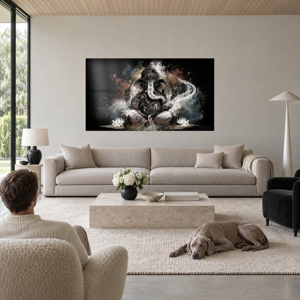 Wall art black and white Ganesh seated in lotus position amid sepia smoke, two white flowers, above a sofa in a bright living room
