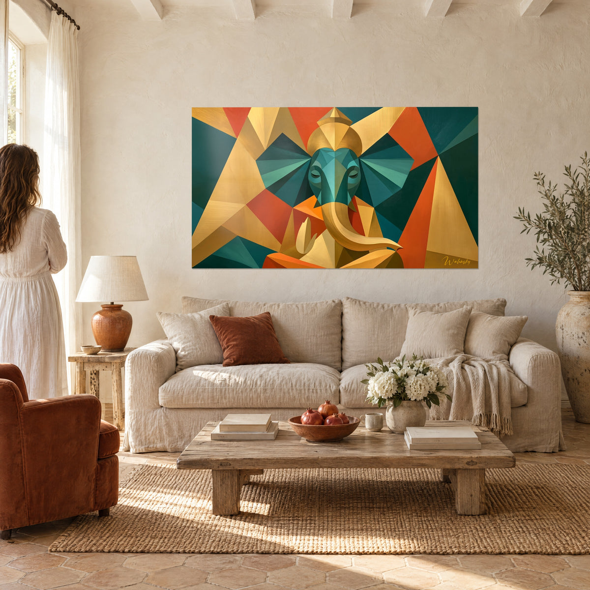 Wall art Ganesh in geometric turquoise and gold facets, ochre trunk, a woman seen from behind above a sofa in a bright living room