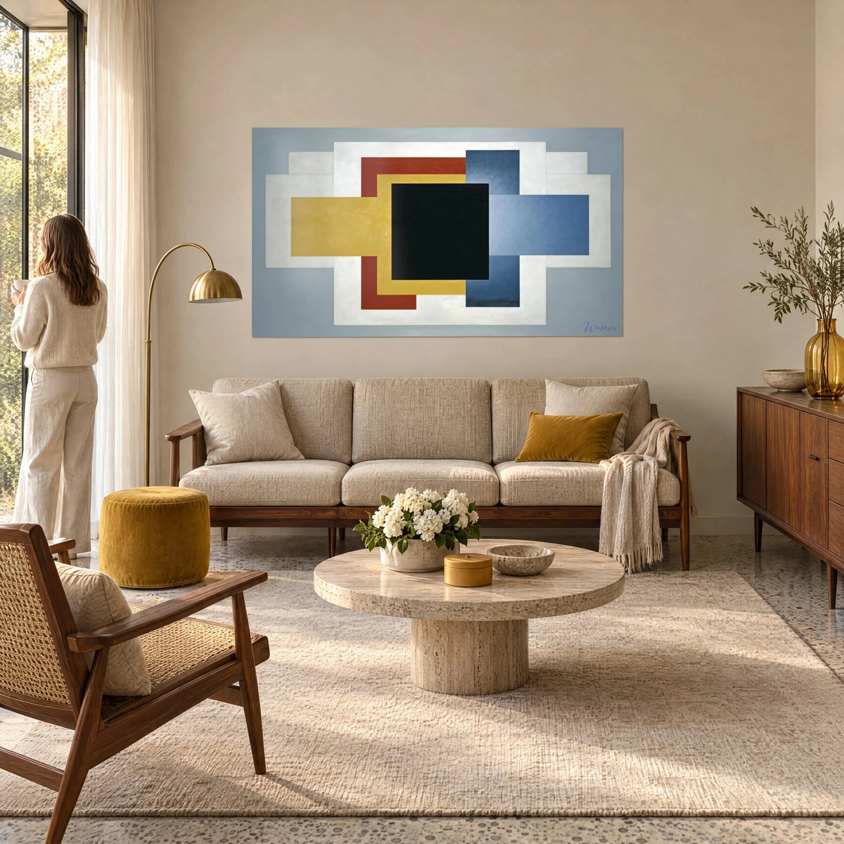 Tableau carré noir cerné d'ocre jaune et de rouge brique sur fond blanc, couple de dos au-dessus d'un canapé dans un salon lumineux