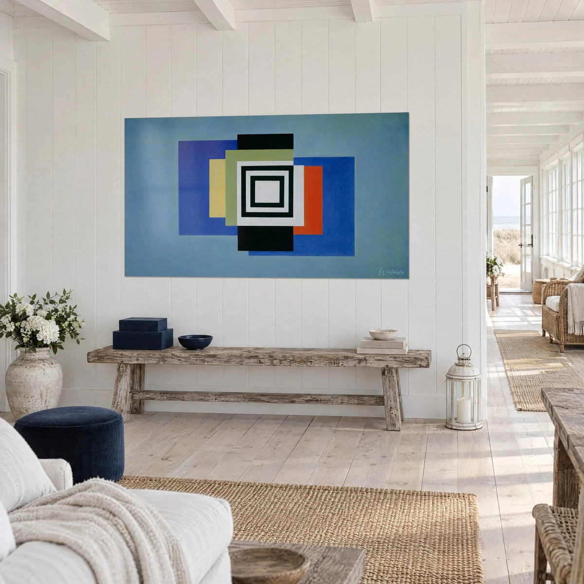 Wall art geometric composition of overlapping rectangles in cobalt blue and orange, on white paneled wall, three-quarter view
