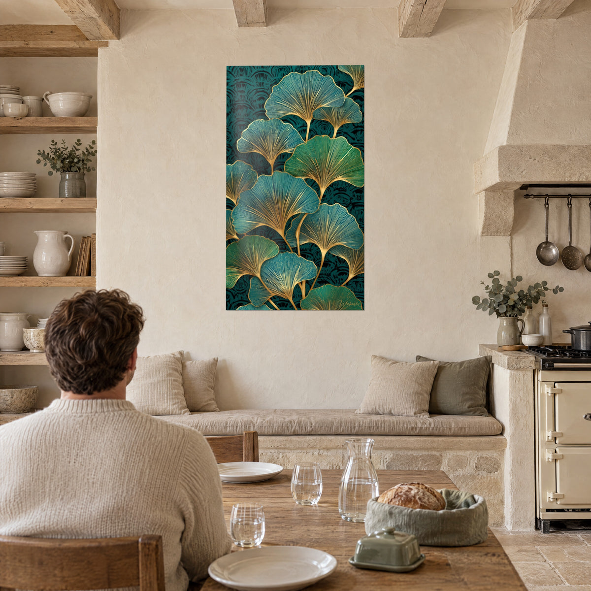 Cuadro ginkgo biloba con nervaduras doradas sobre fondo malaquita, azul pavo real y verde, frente a una mesa en una cocina de piedra