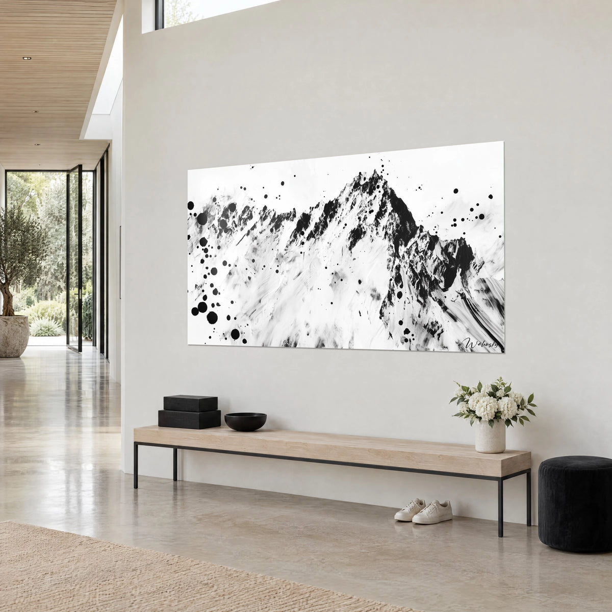 Cuadro macizo rocoso de aristas negras, nieve blanca estriada con pincel, gotas de tinta dispersas, pared beige de una casa de arquitecto