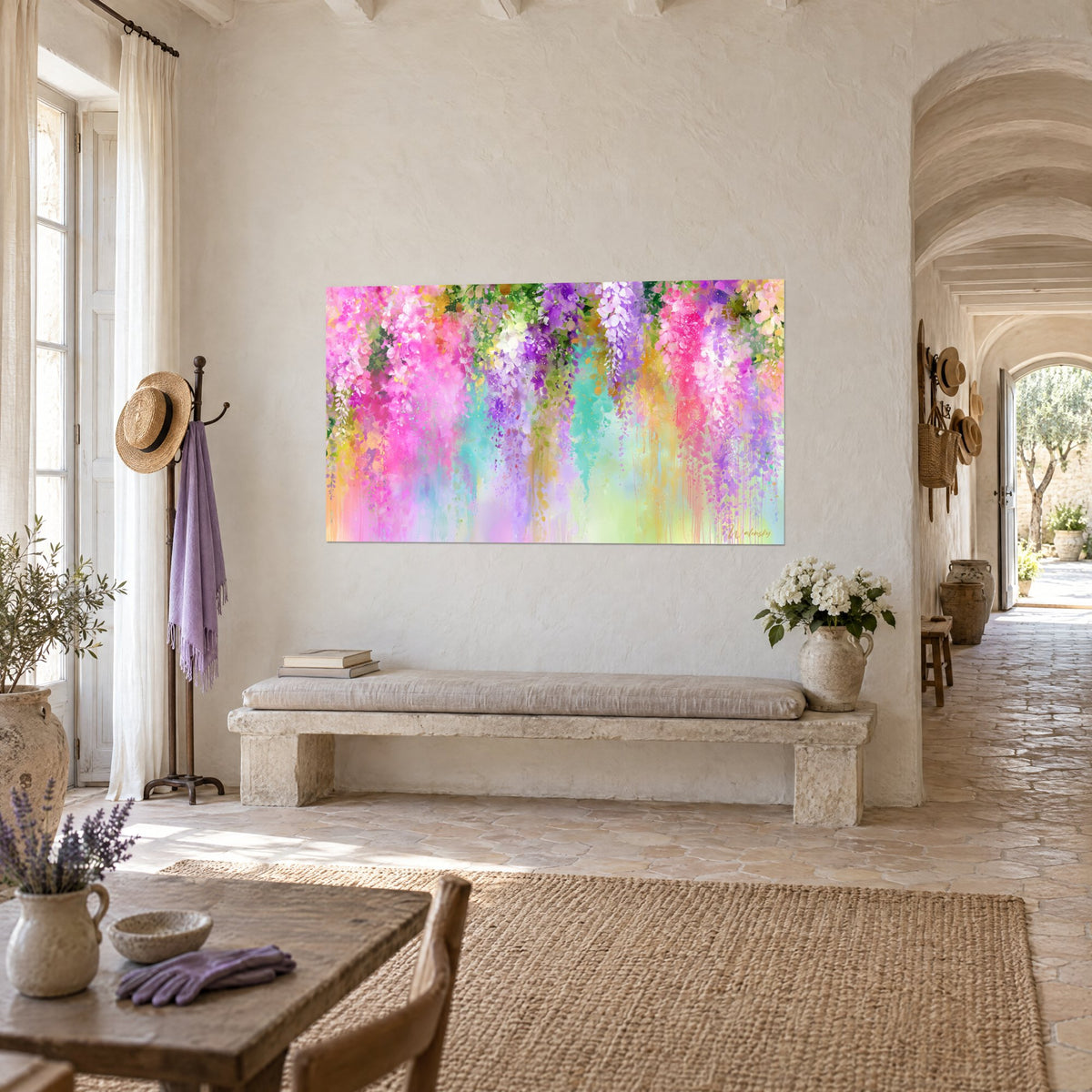 Cuadro de racimos de glicina rosa vivo y morado con goteos de acuarela, colgado en una pared blanca junto a un arco, masía provenzal