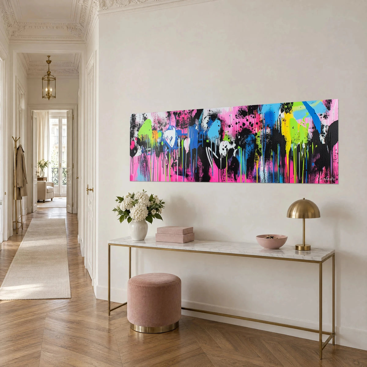 Tableau street art panoramique éclaboussé de noir, bleu et jaune fluo, vu de trois quarts au-dessus d'une console dorée dans un couloir haussmannien