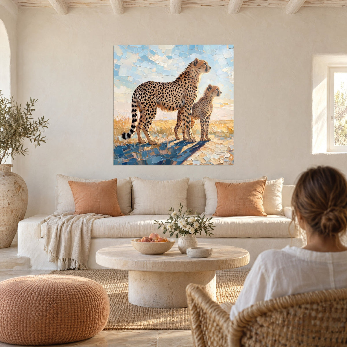 Tableau guépard et son petit scrutant l'horizon, pelage ocre, ciel bleu en touches de couteau, au-dessus d'un canapé dans un salon lumineux
