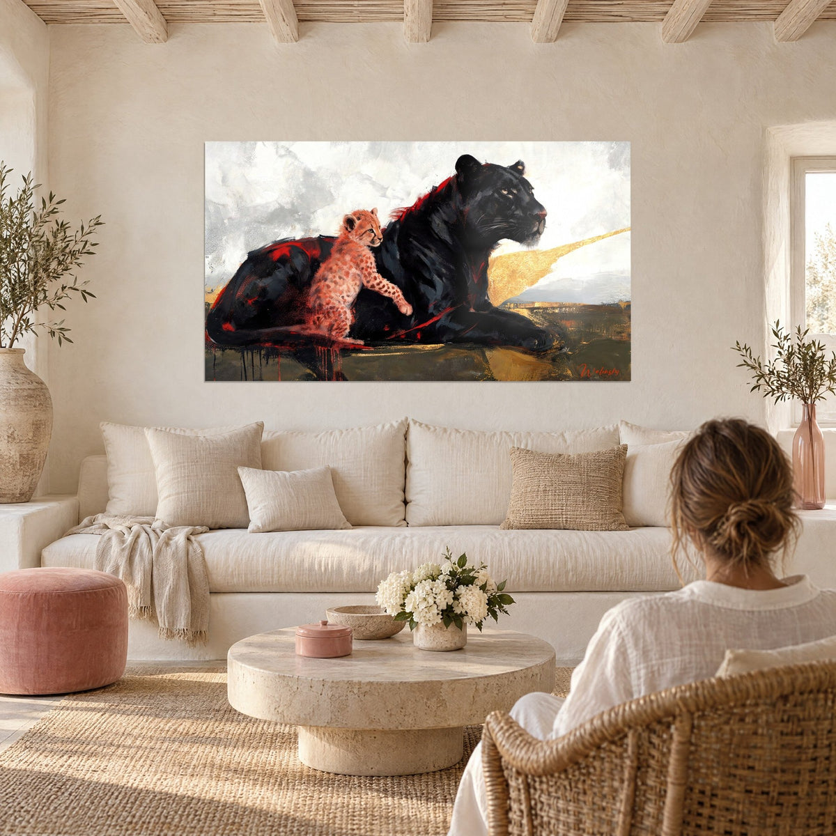 Tableau panthère noire couchée, petit guépard rose accoudé, éclat doré sur fond gris, au-dessus d'un canapé dans un salon lumineux