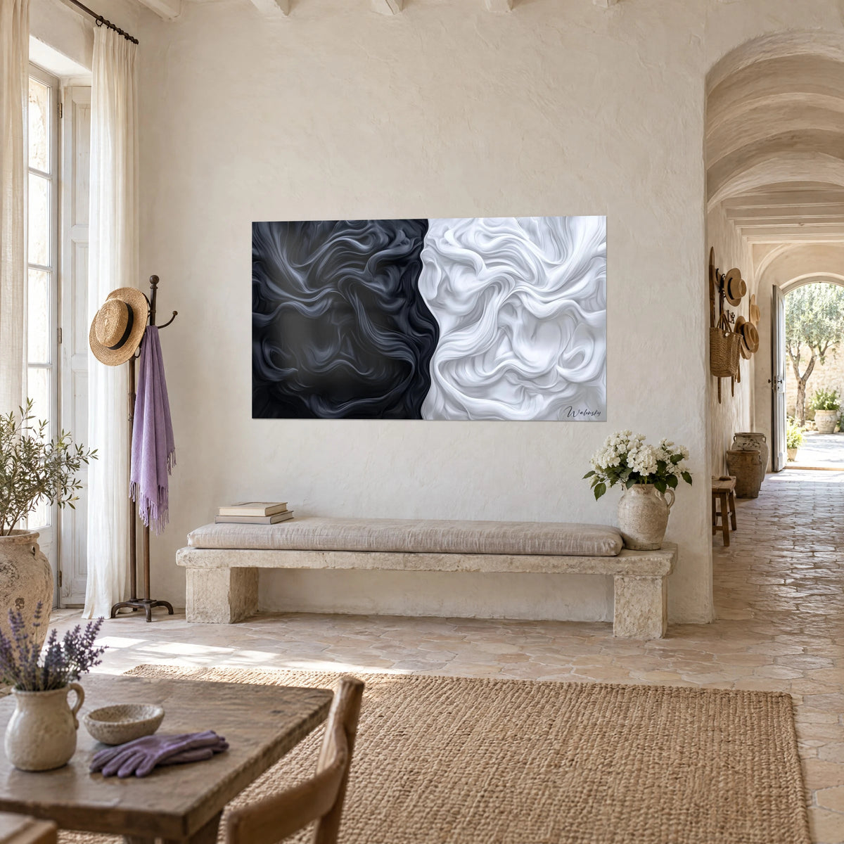 Wall art of sculpted anthracite and cream-white folds facing a stone bench, on the beige wall of a vaulted farmhouse hallway