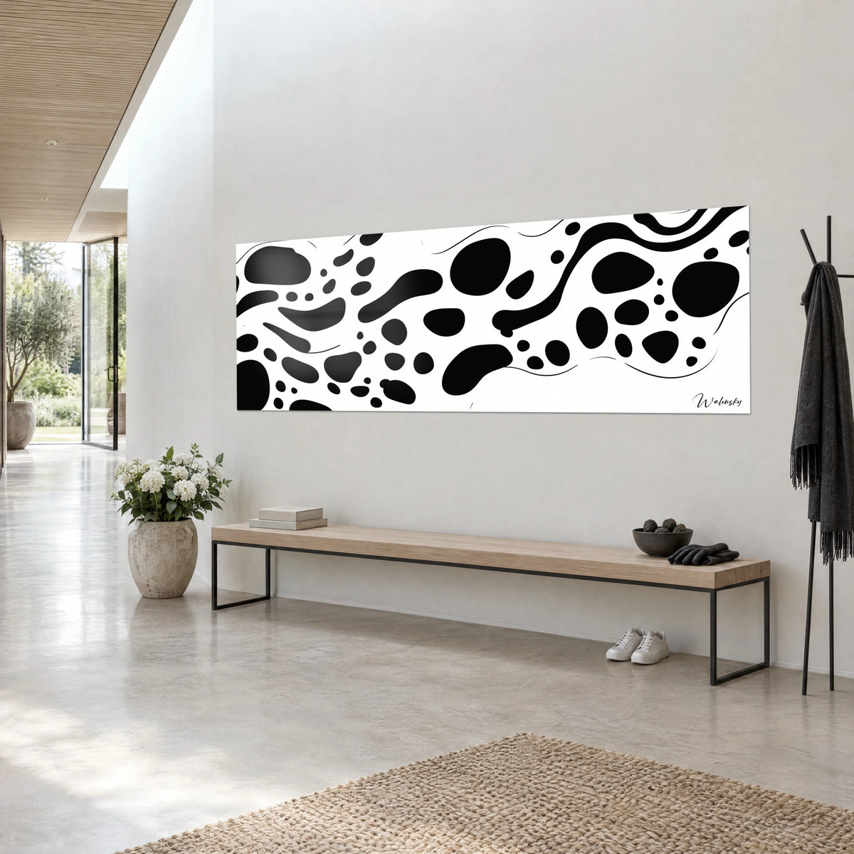 Quadro motivo maculato in bianco e nero, grandi macchie arrotondate e onde d'inchiostro, visto di tre quarti su una parete grigio chiaro