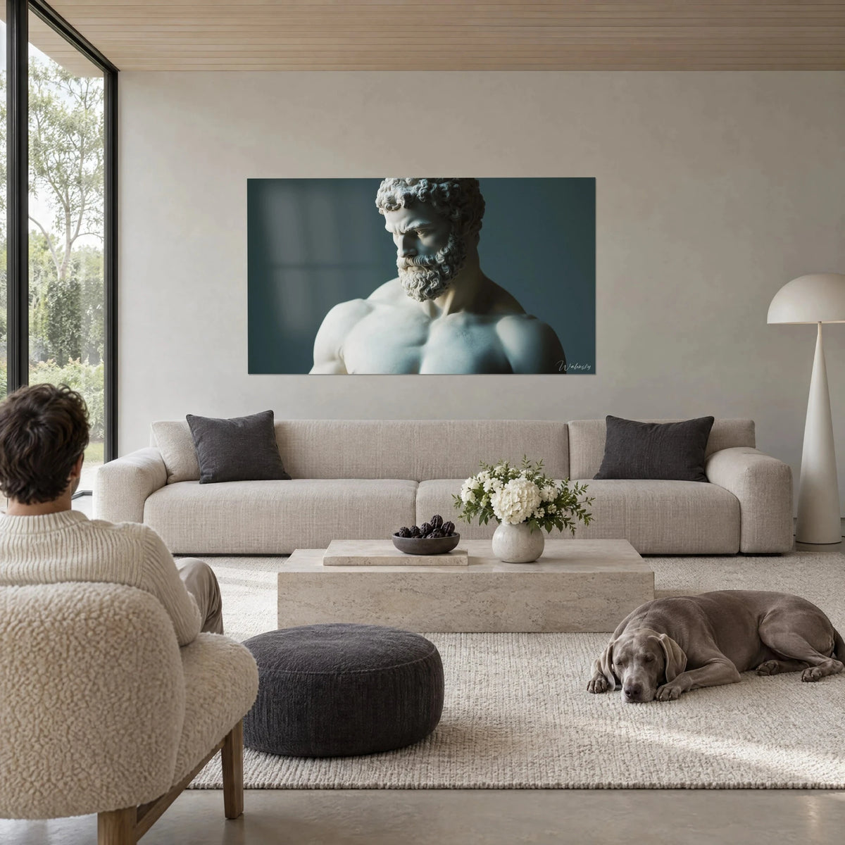 Tableau Hercule barbu en marbre blanc, regard baissé sur fond bleu ardoise, au-dessus d'un canapé dans un salon lumineux