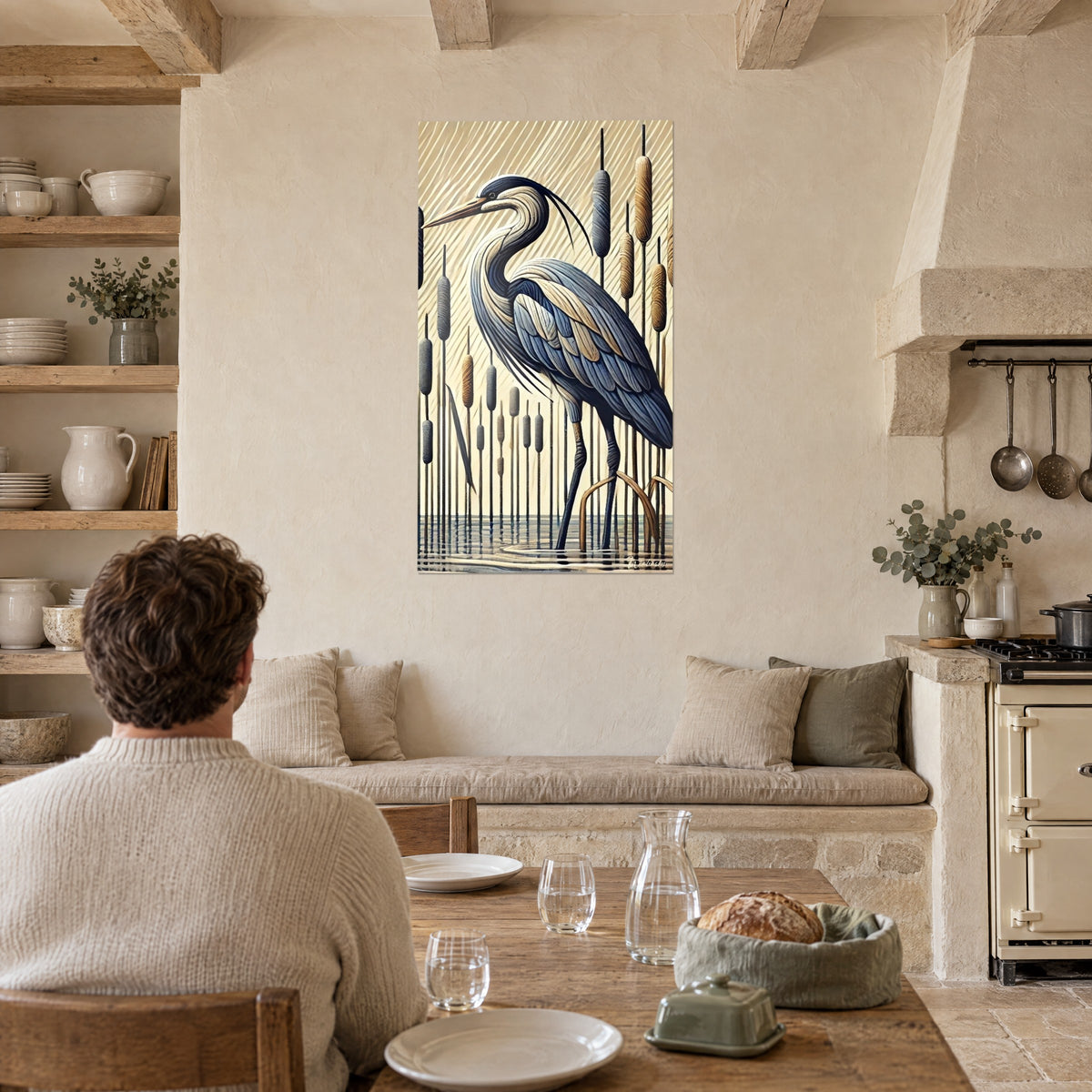 Tableau héron en plumes ardoise et sable, quenouilles brunes et grises, un homme de dos attablé devant une cuisine en pierre