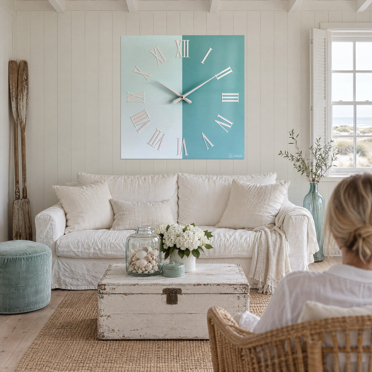 Cadran bicolore blanc et bleu sarcelle de cette horloge suspendu au-dessus d'un lit dans une chambre claire