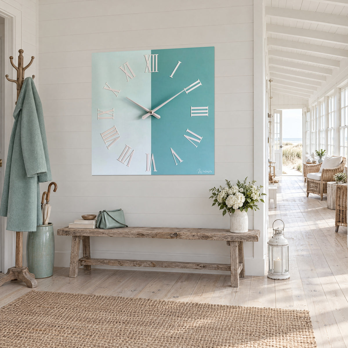 Chiffres romains argentés de cette horloge blanc et bleu sarcelle accrochée au-dessus d'un canapé dans un salon lumineux