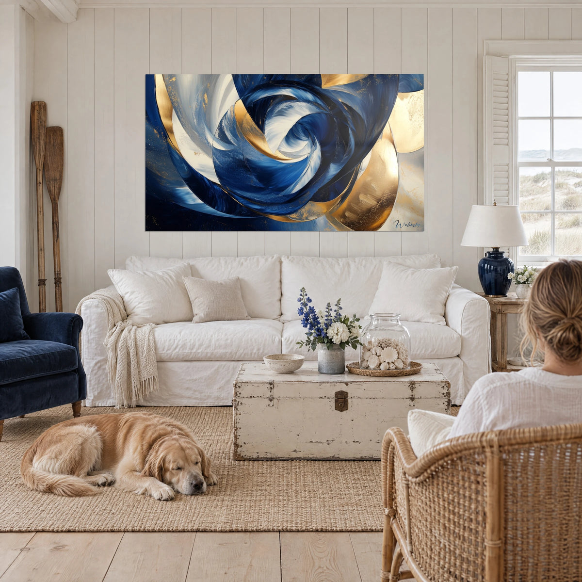 Cuadro con espiral hipnótica en azul noche y oro, remolinos blancos, golden retriever tumbado, encima de un sofá en un salón luminoso