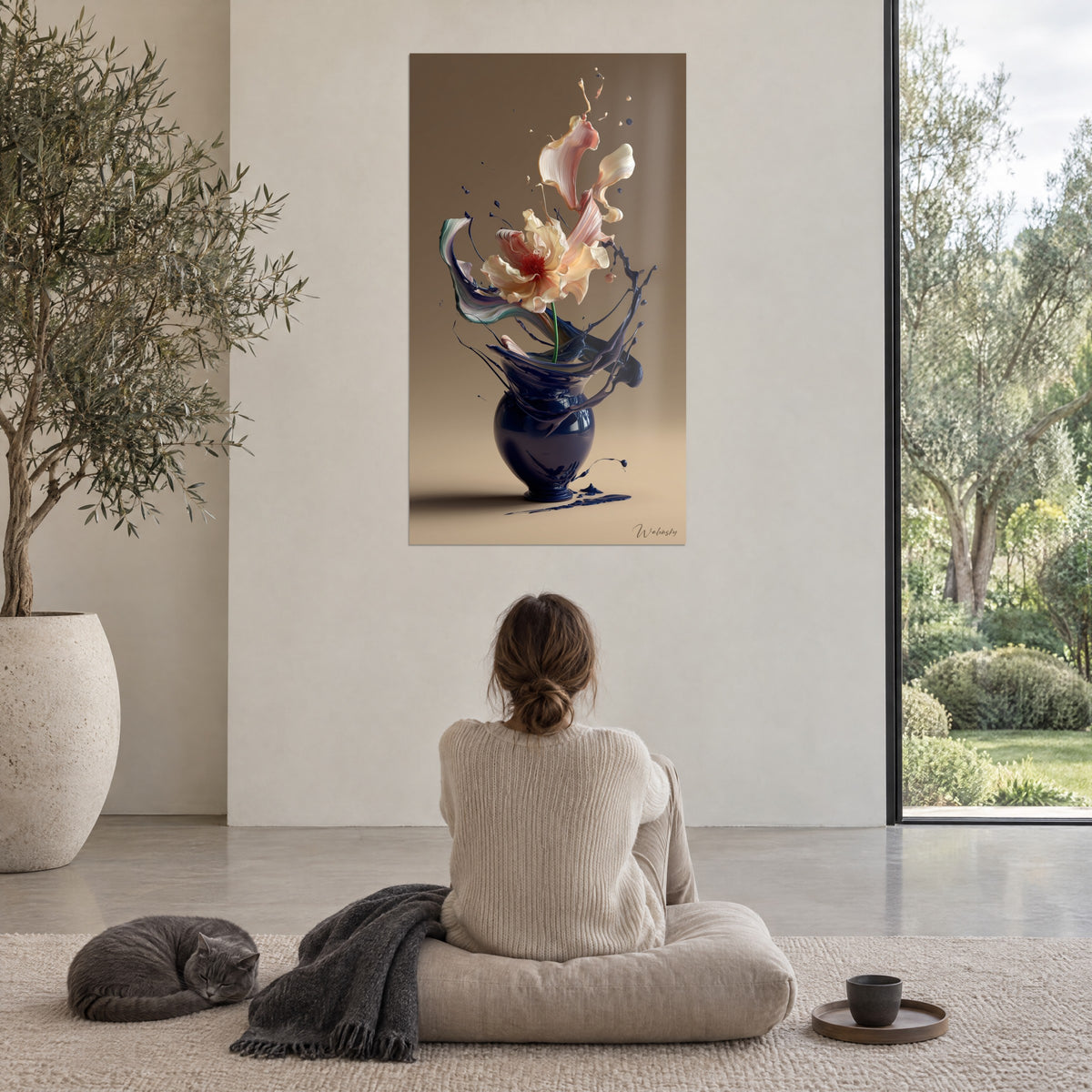 Tableau éclat floral rose et crème dans un vase bleu profond, fond sable, face à une femme assise sur un coussin et un chat gris
