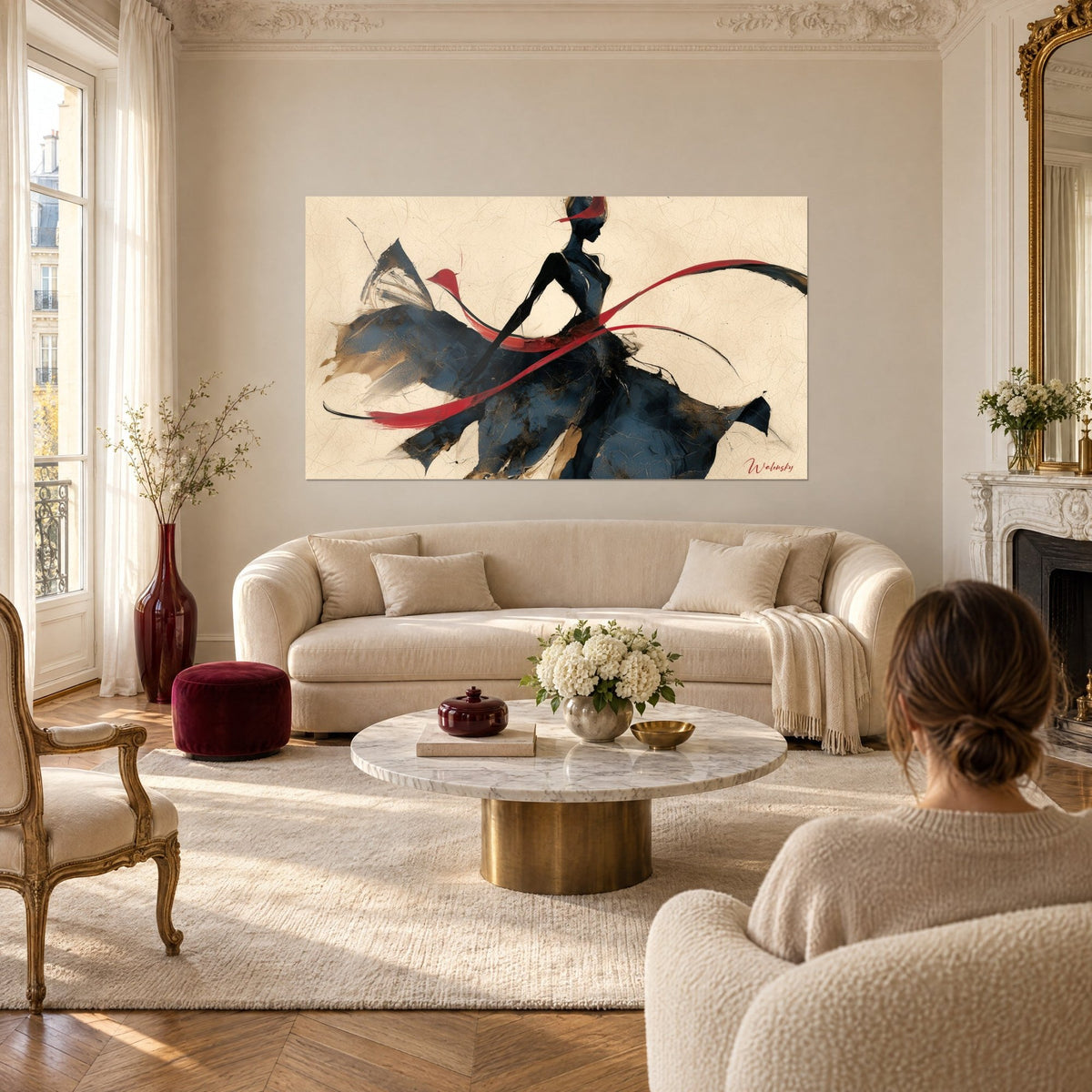 Tableau danseuse élancée en robe bleu nuit tourbillonnante, rubans rouges sur fond crème, au-dessus d'un canapé dans un salon lumineux