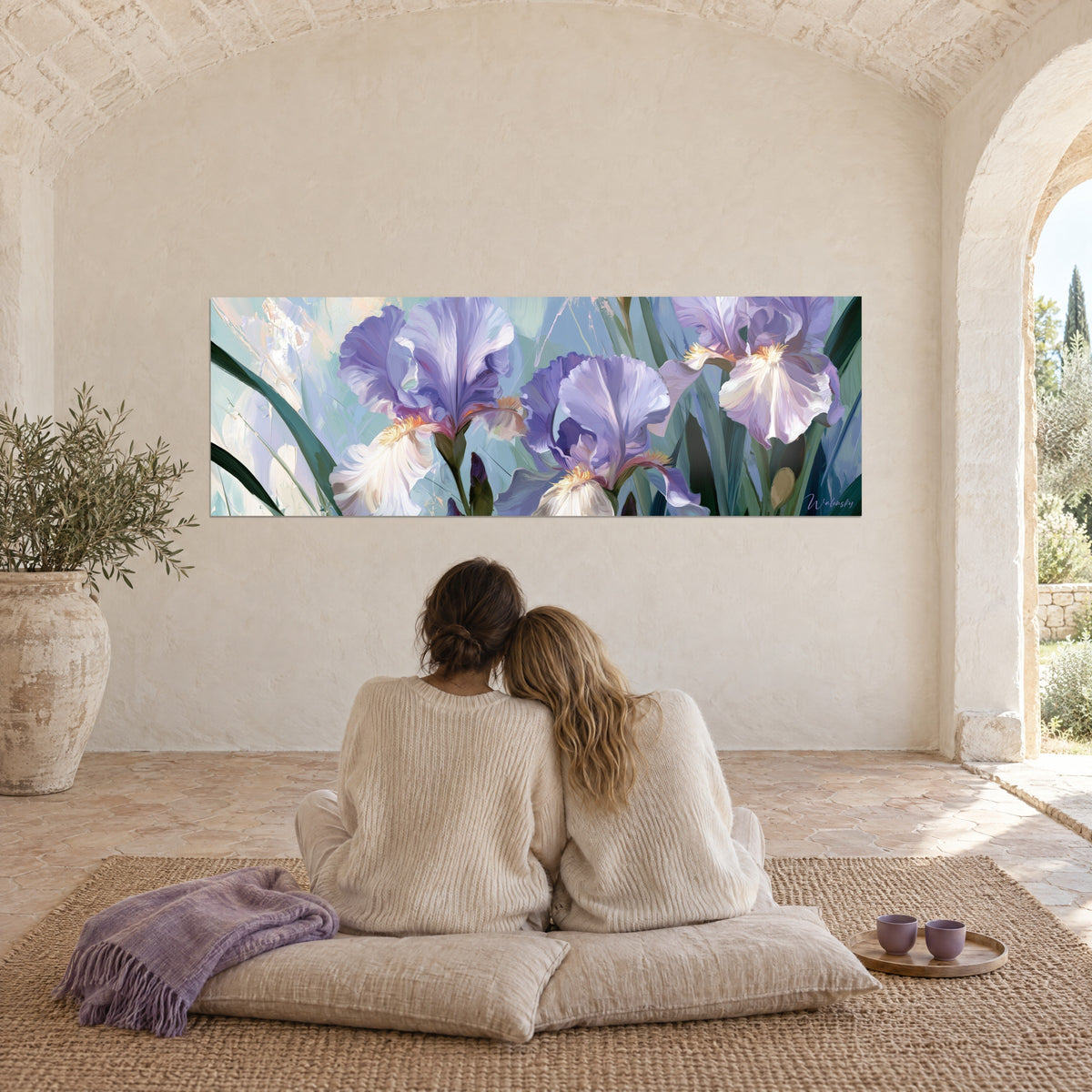 Cuadro de corolas de iris violeta y blanco, tallos verde profundo sobre fondo pastel, dos mujeres de espaldas sobre cojines, en un mas