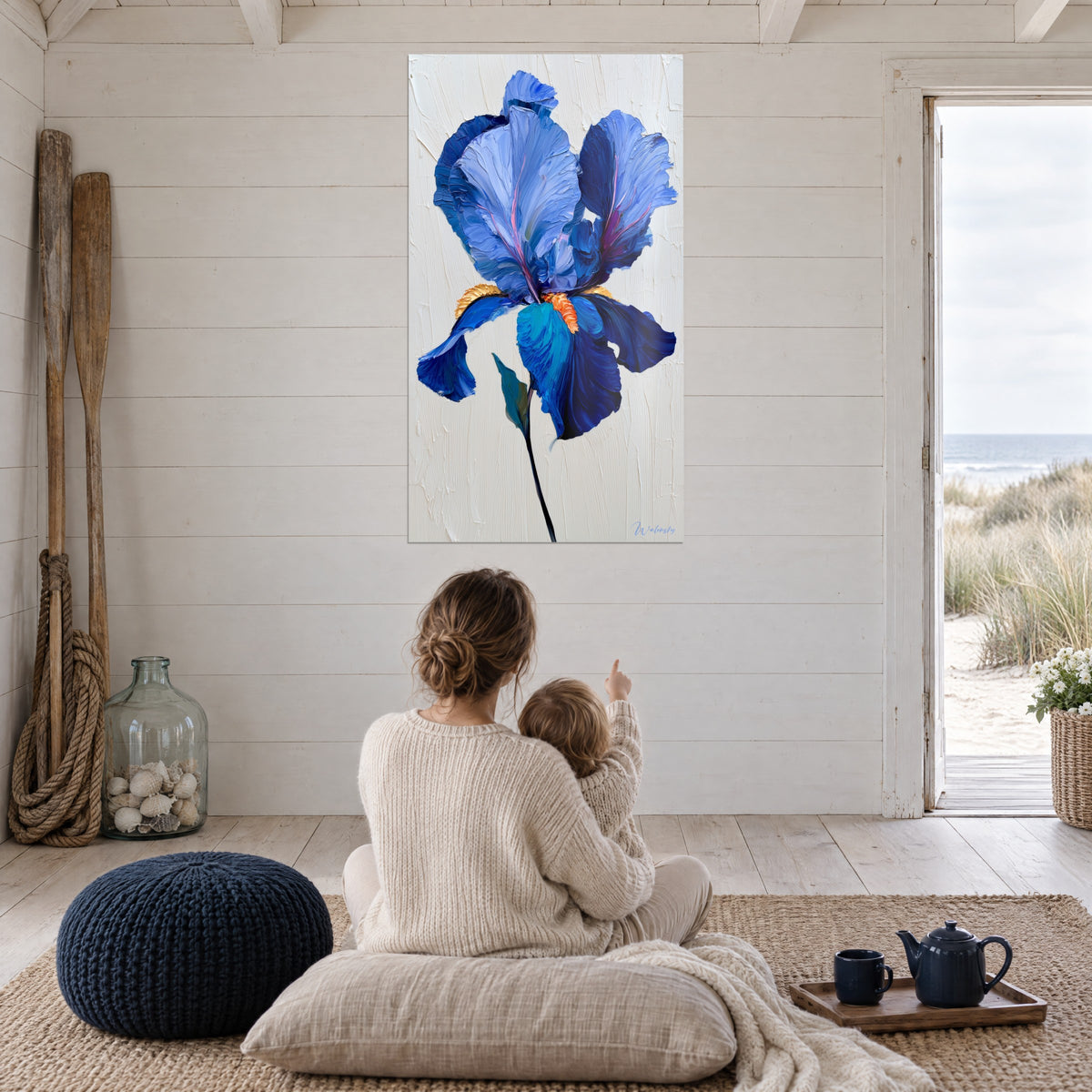 Schilderij met koningsblauwe bloem op getextureerde ivoorkleurige achtergrond, donkere steel, tegenover een moeder met baby bij het strand