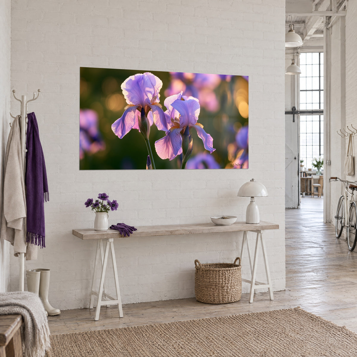 Cuadro de flores de iris lila de pétalos venados, bokeh ámbar y follaje oscuro, sobre una pared blanca en vista de tres cuartos
