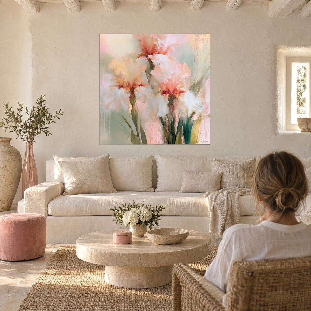 Gemälde Iris in Weiß mit Pfirsich- und Kupferfalten, salbeigrüne Stiele, Person von hinten, über einem Sofa in einem hellen Wohnzimmer
