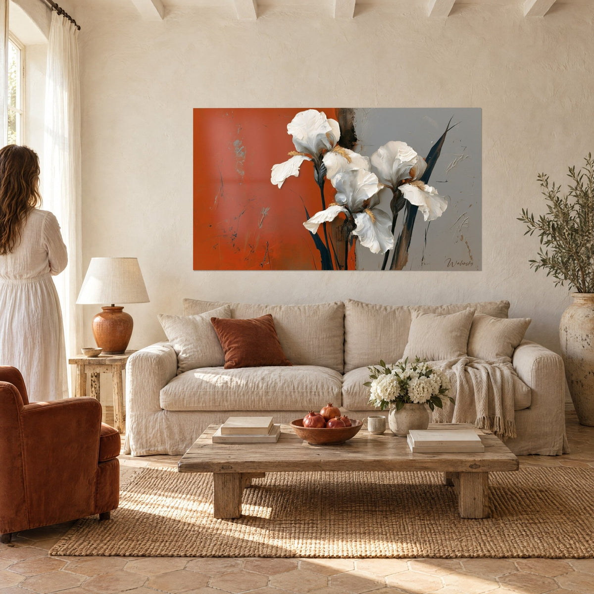 Cuadro iris blancos en empastes gruesos sobre fondo naranja y gris, pareja de espaldas, sobre un sofá en un salón luminoso
