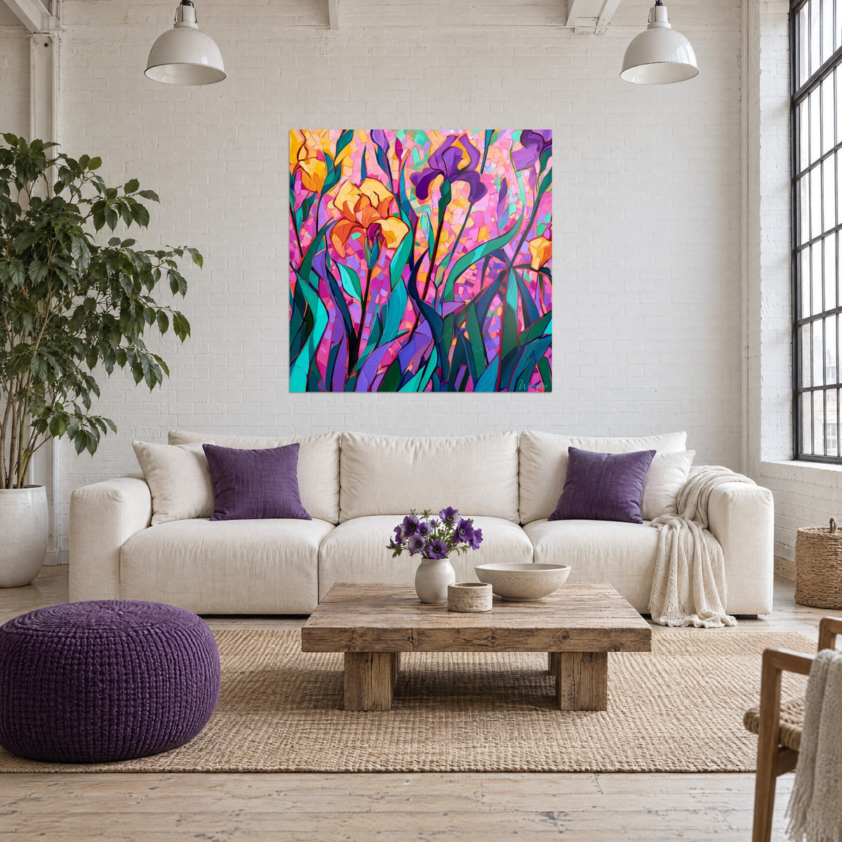 Cuadro con iris amarillos y violetas en mosaico rosa, hojas verde esmeralda, sobre un sofá en un salón luminoso