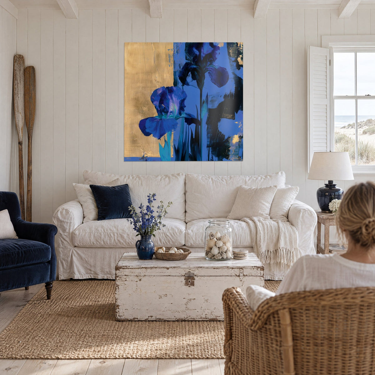 Wall art Indigo iris with crumpled petals on a patinated gold background, two people seen from behind, above a sofa in a bright living room