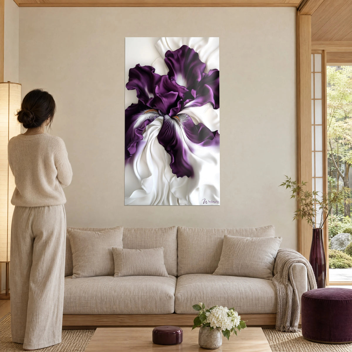 Gemälde Iris in Purpur mit satinierten, gefältelten Blütenblättern auf cremeweißem Grund, Frau von hinten, über einem Sofa in einem lichtdurchfluteten Wohnzimmer