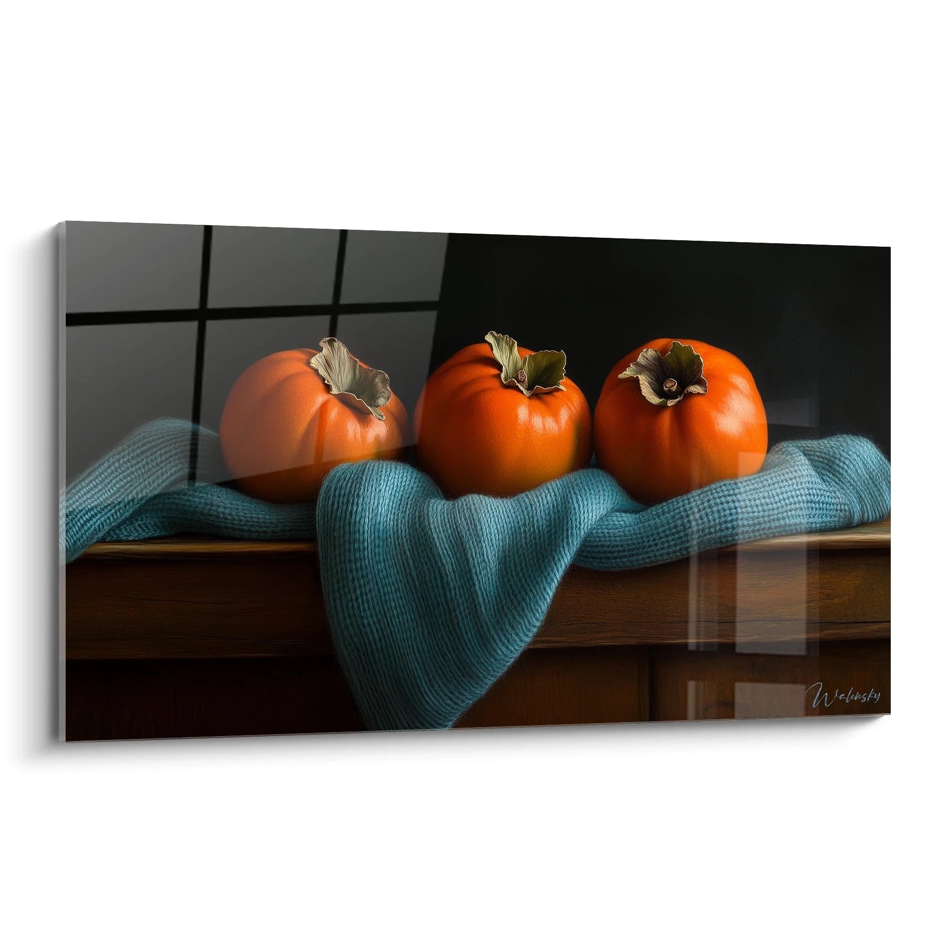 Un tableau kaki présentant trois kakis orange vif posés sur une surface en bois, entourés d’un tissu bleu texturé, avec un fond noir uni et des contrastes de lumière marqués.