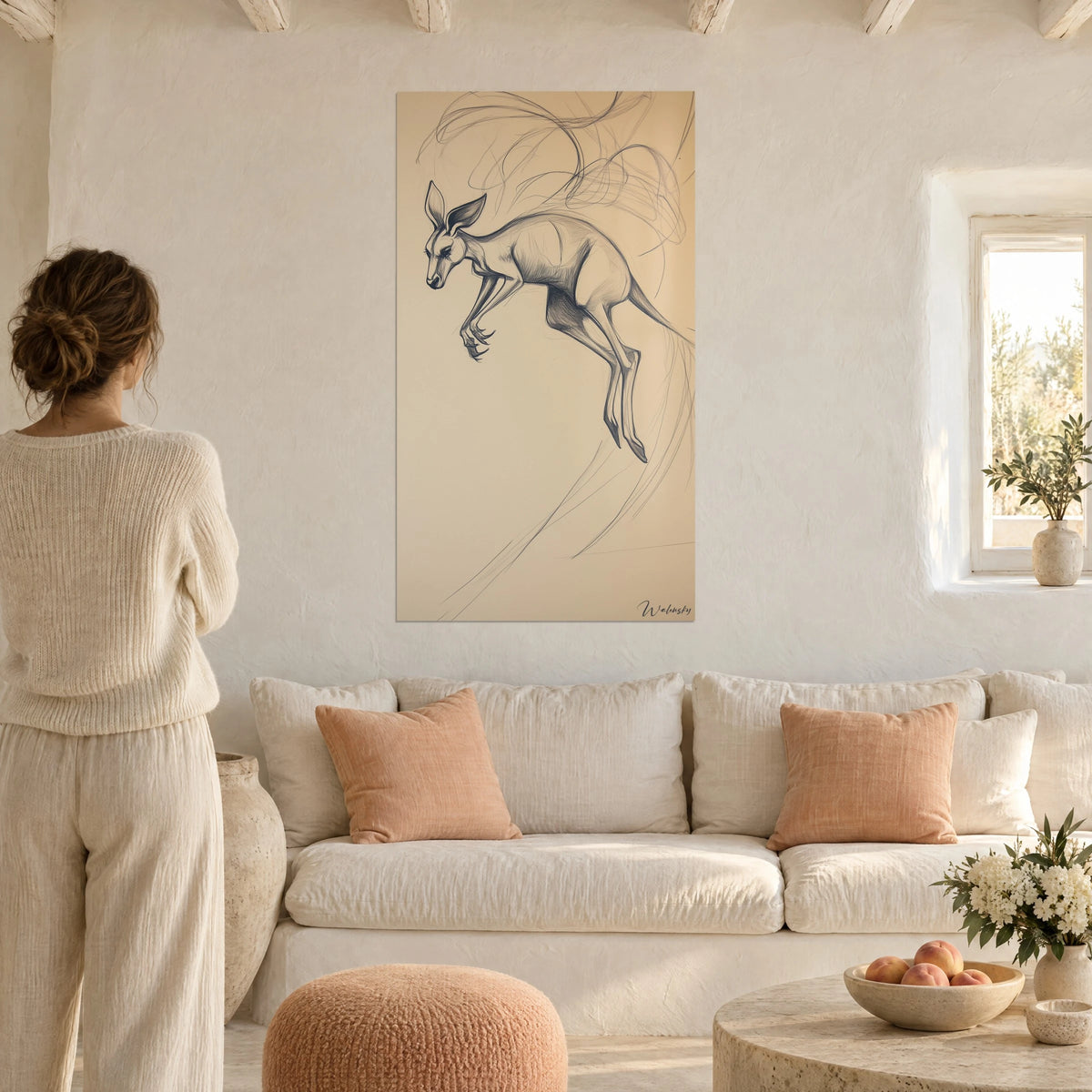 Gemälde eines springenden Kängurus in nachtblauem Bleistift auf sandfarbenem Grund, über einem Sofa in einem hellen Wohnzimmer