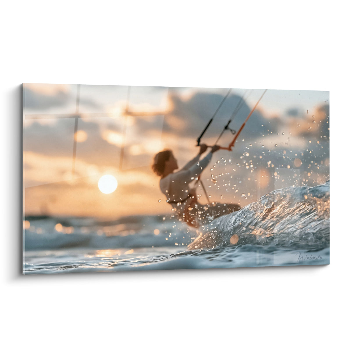 Kitesurfeur silhouette dorée fendant une vague, éclaboussures bleu pastel et gris sous coucher de soleil ambré