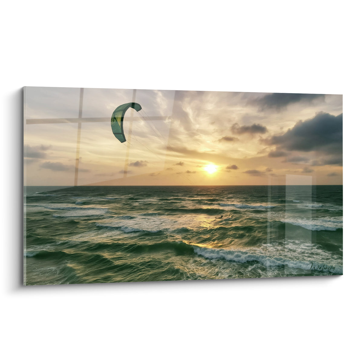 Kite surfeur sur voile verte glisse face au soleil doré, vagues vert émeraude et ciel anthracite