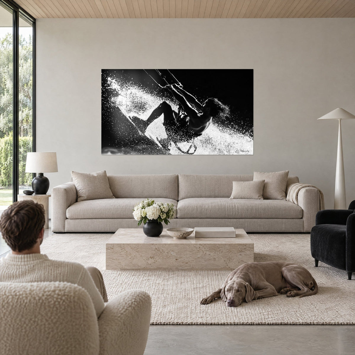 Tableau kitesurfeur en suspension, gerbe d'eau blanche sur fond noir, couple de dos, Weimaraner couché, au-dessus d'un canapé dans un salon lumineux