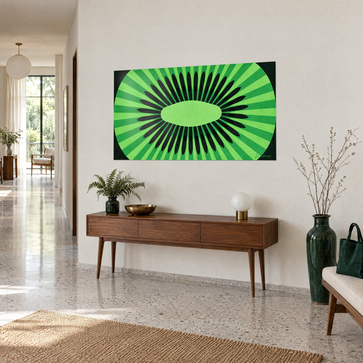 Wall art cut fruit in a green rosette, light green oval heart and black seeds, on a cream wall above a wooden sideboard