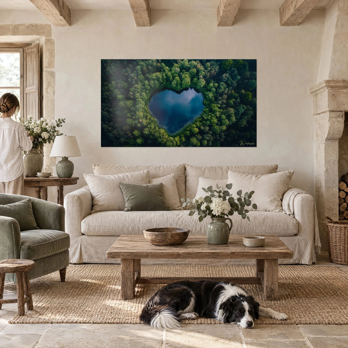 Quadro lago a forma di cuore blu notte circondato da bosco verde scuro, collie accovacciato, sopra un divano in un soggiorno luminoso