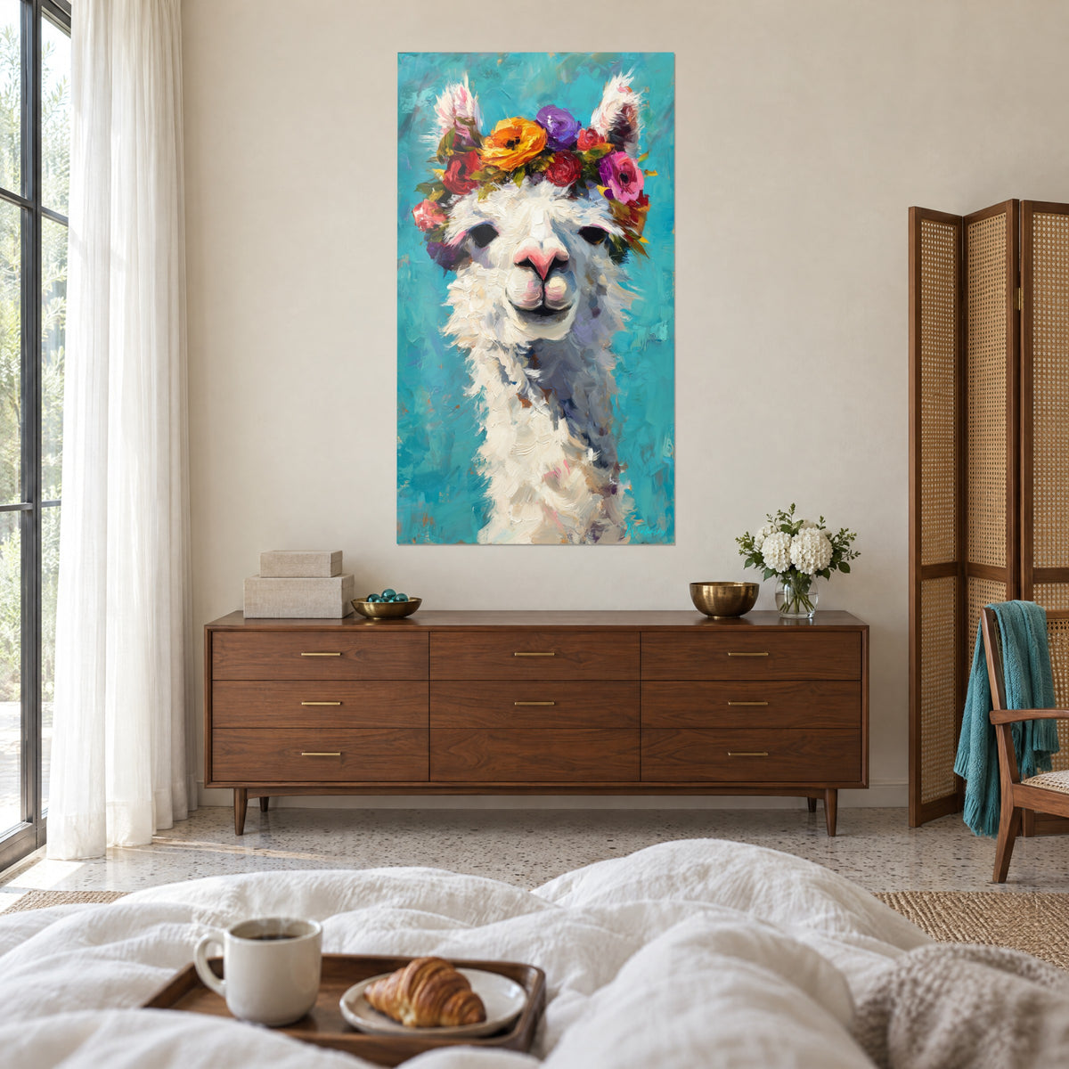 Cuadro camélido de lana blanca y nariz rosa, corona de flores amarillo anaranjado y púrpura, fondo azul pato, encima de una cama en un dormitorio claro