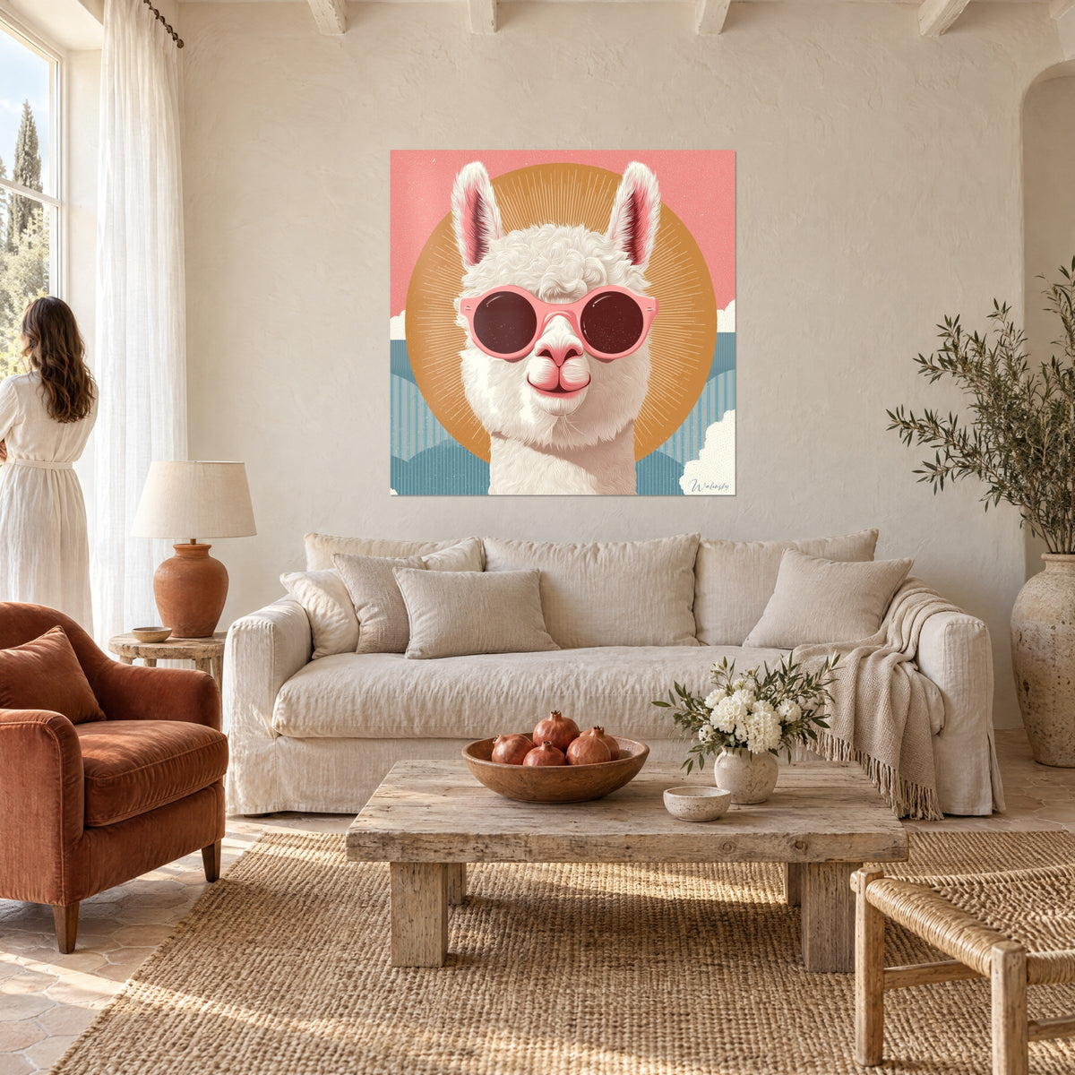 Wall art of a curly white llama with round pink glasses in front of an ochre sun, coral background, above a sofa in a bright living room
