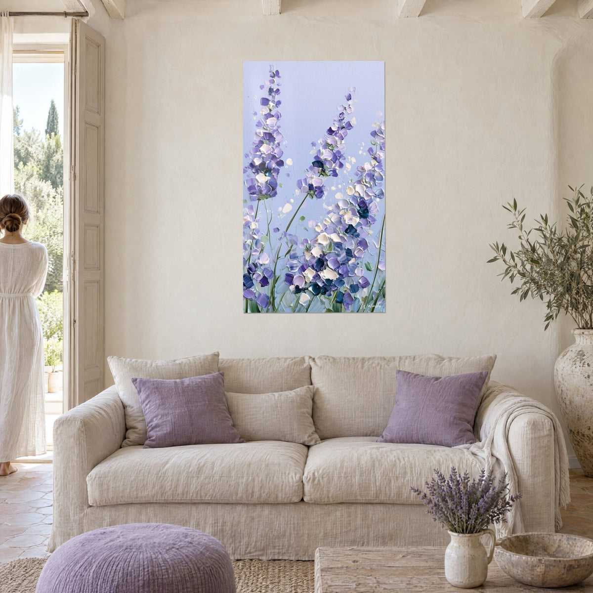 Cuadro espigas de lavanda en pasta gruesa, violeta y blanco crema sobre cielo azul pálido, encima de un sofá en un salón luminoso