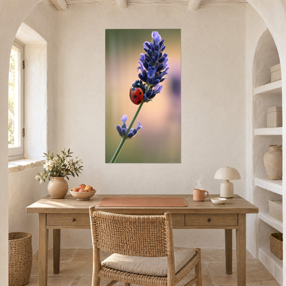Tableau lavande en fleurs et coccinelle carmin sur tige verte, fond ocre rosé, près d'un bureau en bois blond