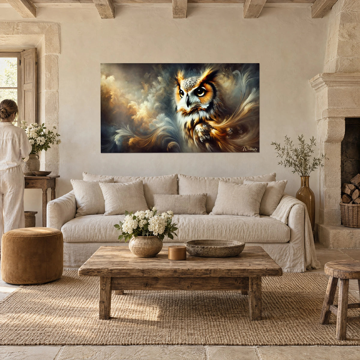 Quadro di gufo dagli occhi ambrati tra volute di piume dorate e grigie, sopra un divano in un soggiorno luminoso