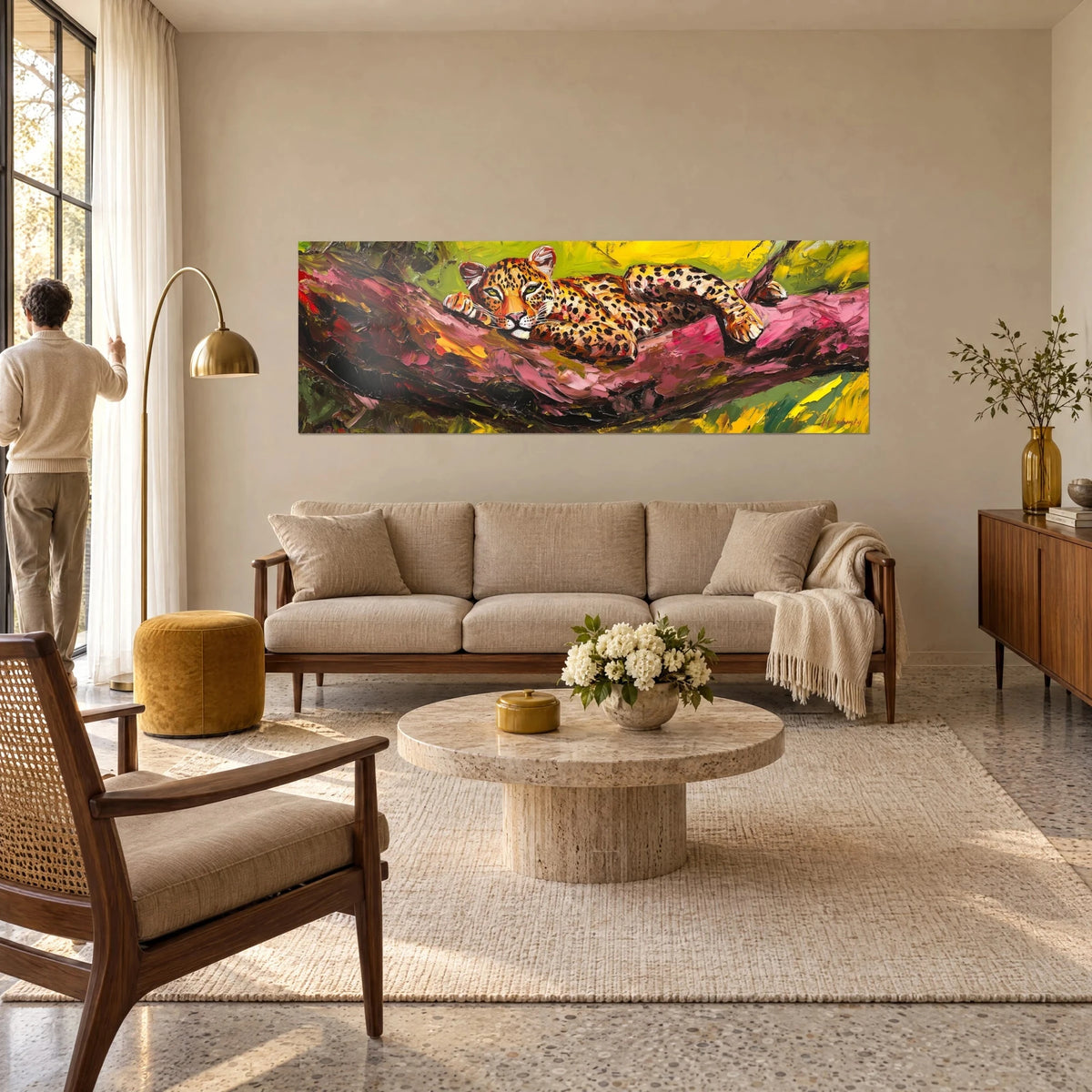 Tableau panthère mouchetée allongée sur une branche rose, fond vert et jaune, homme de dos au-dessus d'un canapé dans un salon lumineux