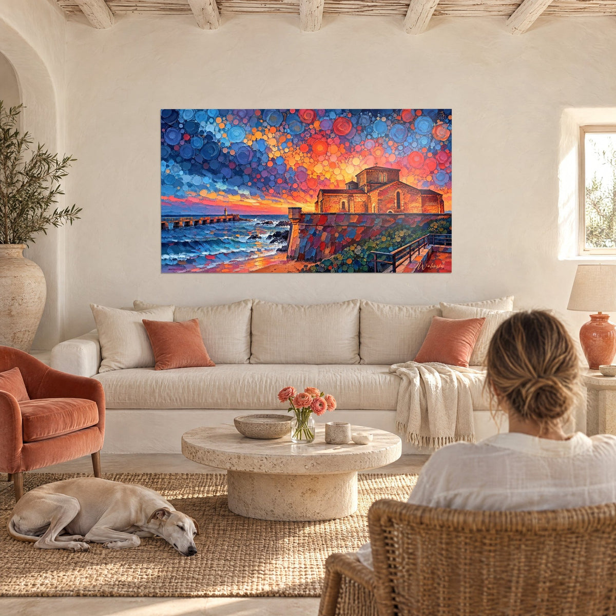 Wall art stone chapel under a sky of orange and blue bubbles, choppy sea, above a sofa in a bright living room
